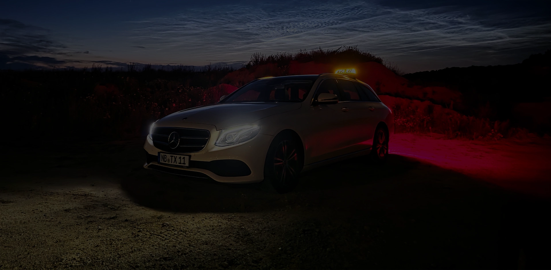 Fahrzeug des Taxiunternehmens Sämann in der Abenddämmerung mit eingeschaltetem Licht.